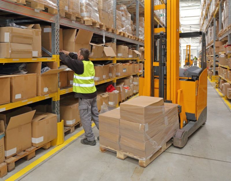 Warehouse employee organizing boxes on shelves as part of cross-docking process to ensure quick outbound shipment
